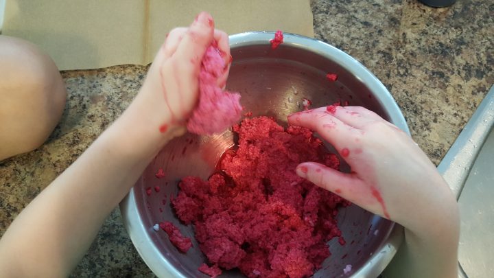 apple craft ideas shows a child squishing red paper pulp.