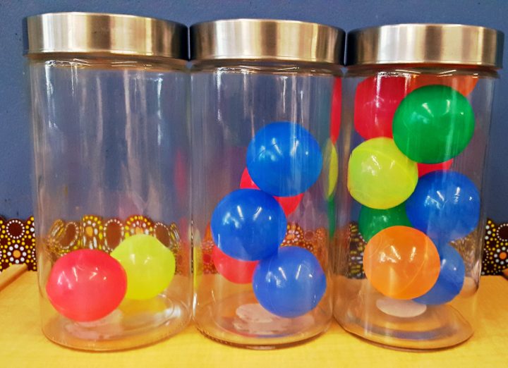 number talks kindergarten shows three jars with different number of ball pit balls in each.