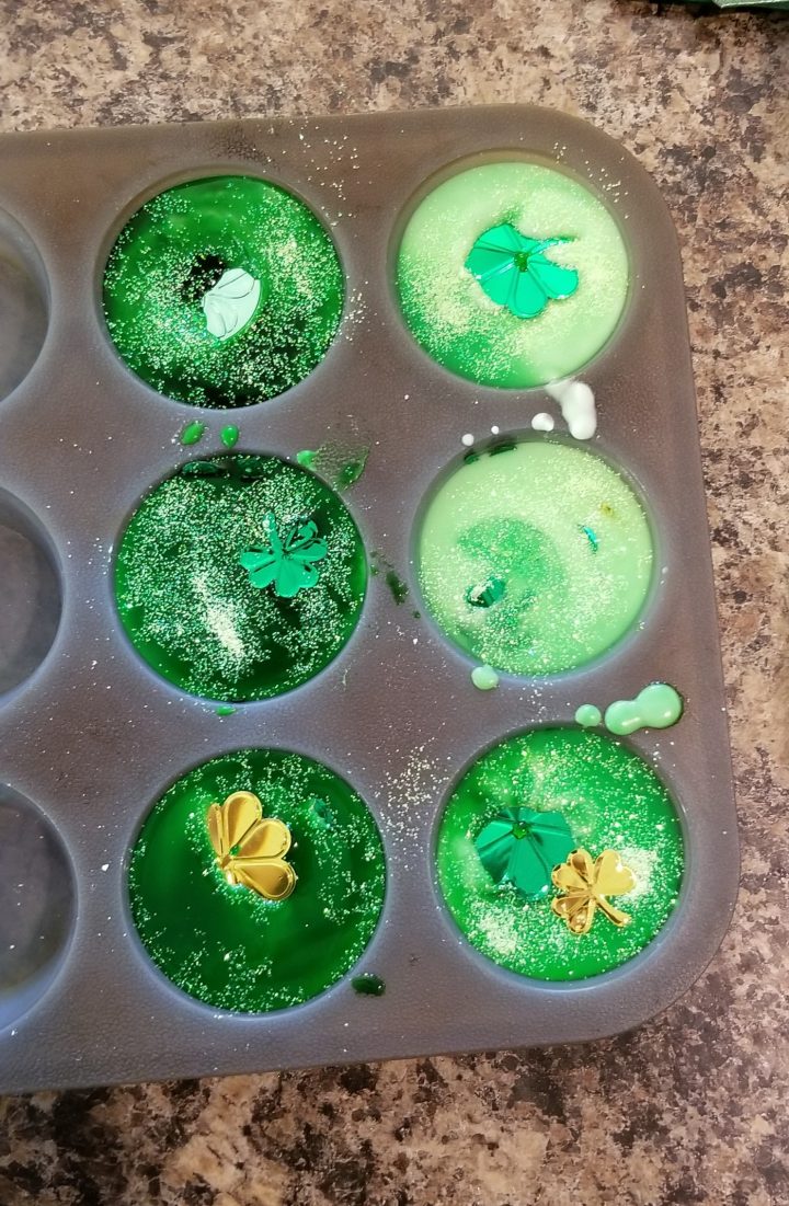 science experiment cupcake liners with green liquid with shamrocks floating in it