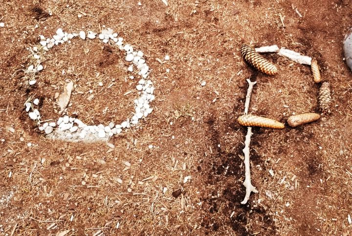 outdoor education shows an o and p formed from stones and sticks.