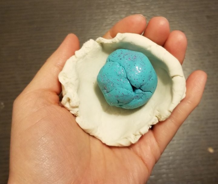 memorable first day of school activity shows a ball of blue playdough wrapped with white dough.