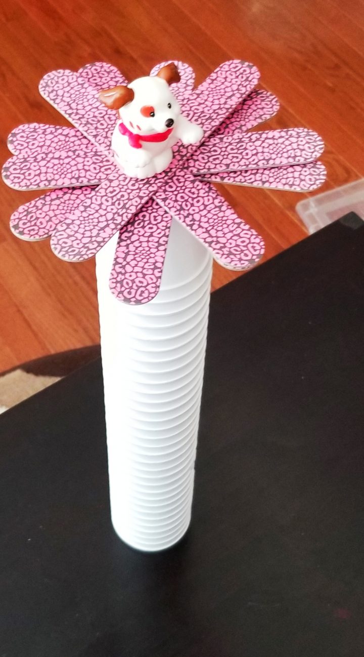 STEM activity shows one stack of styrofoam cups with a spiral of popsicle sticks set on top.