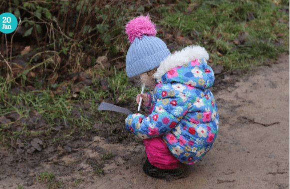 outdoor education shows a child looking at things in the dirt.