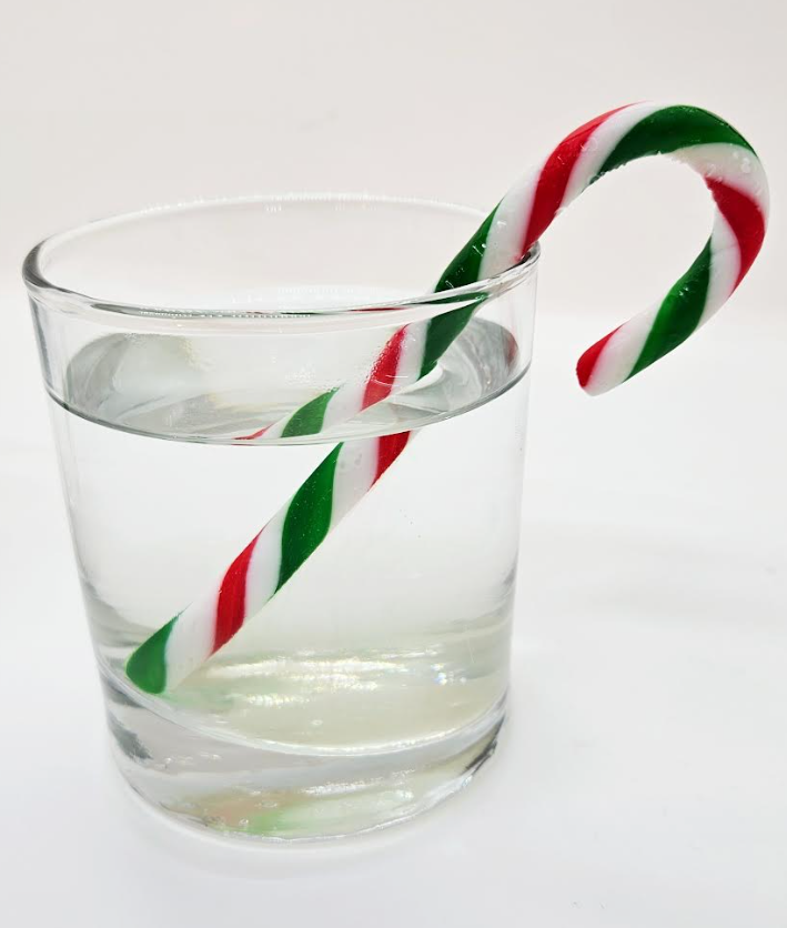 easy science projects with candy canes shows a cup with water and a candy cane.