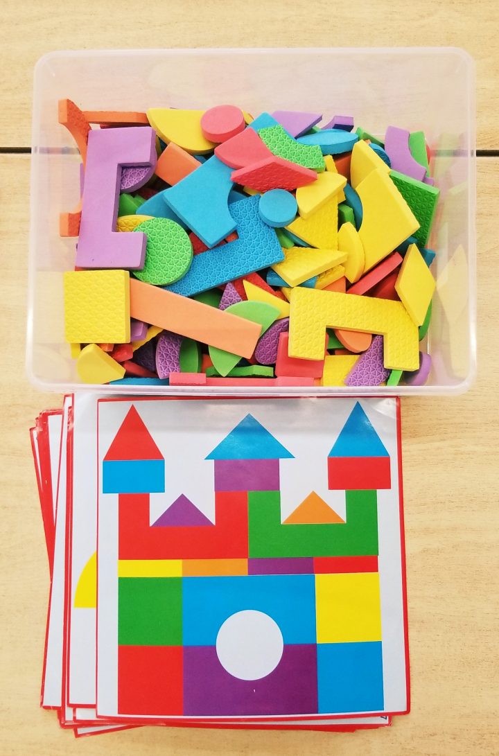 preschool math activity shows a bin of foam shapes and shape boards.