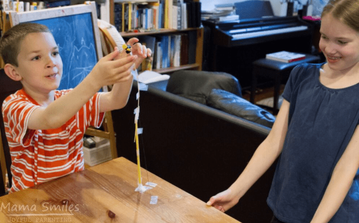 STEM activity shows a child building with spaghetti.