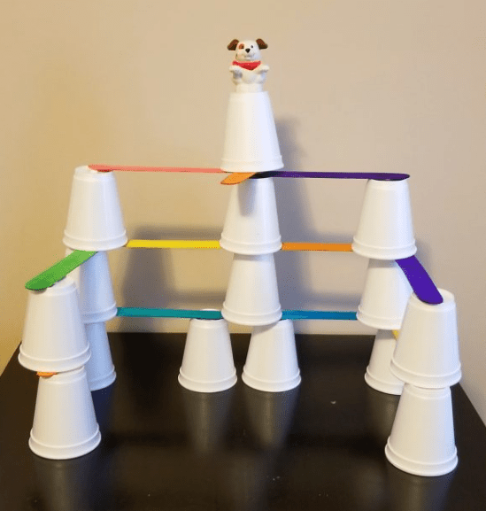 STEM challenges shows cups stacked with popsicle sticks to make a tower.