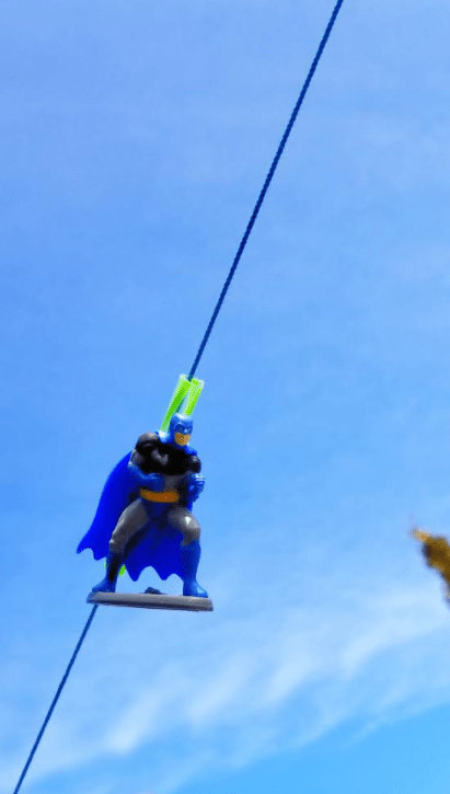 easy science experiments for kids to do at home shows a superhero figure on a string outside.