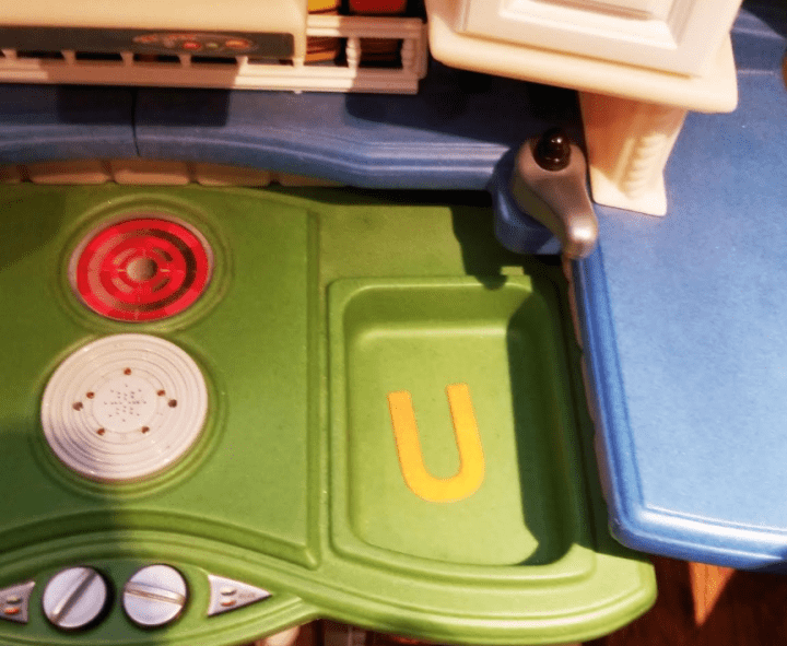 letter games shows the letter U on a children's play kitchen set.