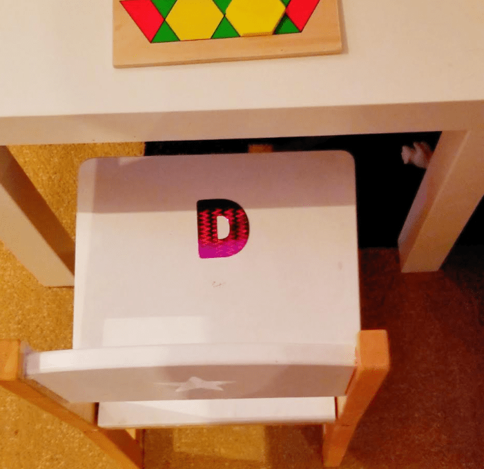 letter games shows a chair with the letter D on it in a toy room.
