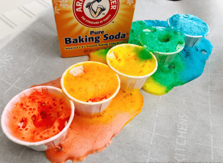science experiments for kids shows five cups with fizzing colorful stuff in each.