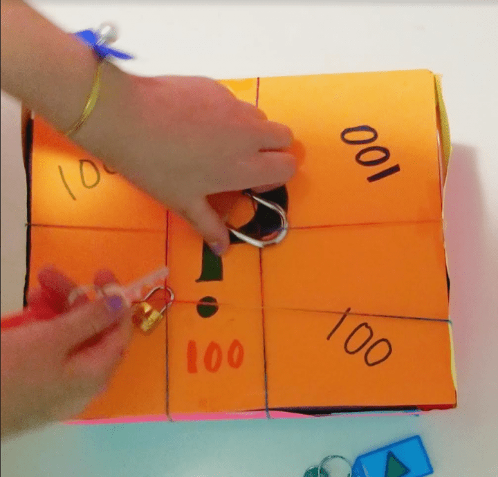 classroom escape room shows a child unlocking a lock on a box.
