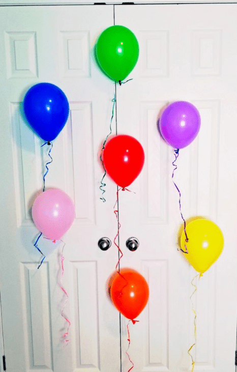 new years escape room.  image shows seven colorful balloons stuck on a door.