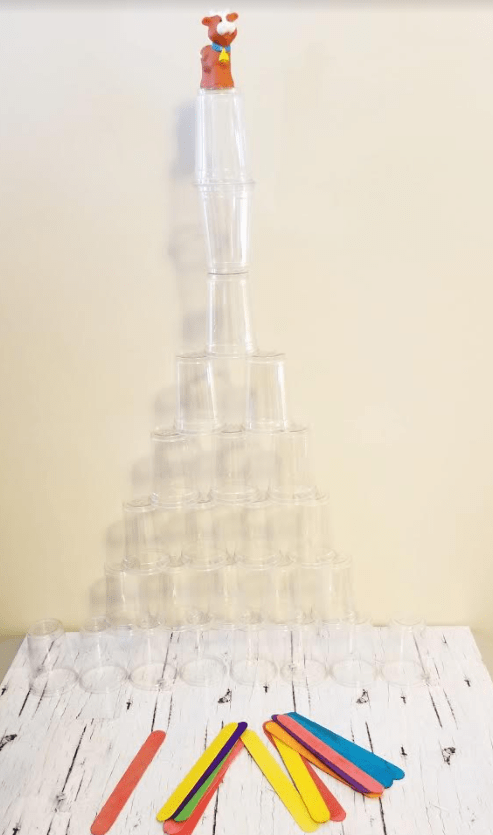stem challenge shows a huge tower made from plastic cups stacked on top of each other and a plastic cow on top.