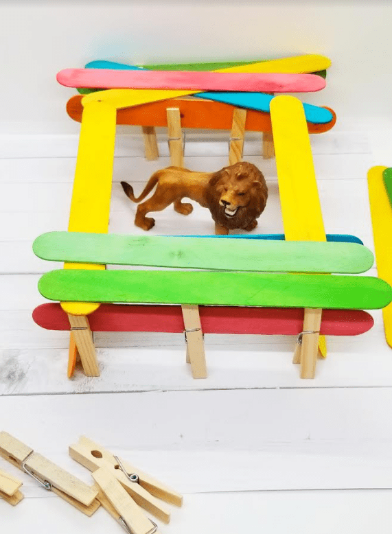 stem for kids shows a toy lion in a popsicle stick house.