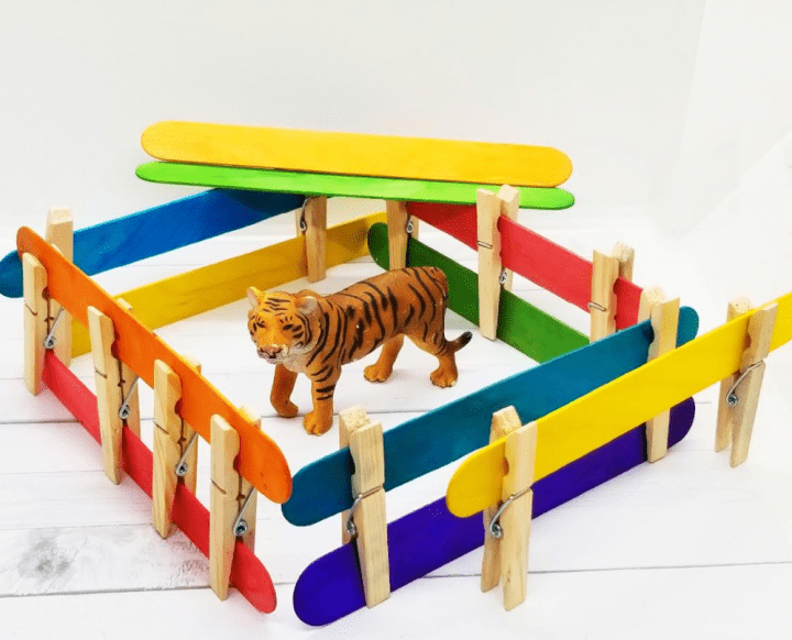 stem for kids shows a toy lion in a popsicle sticks, clothes pin home.