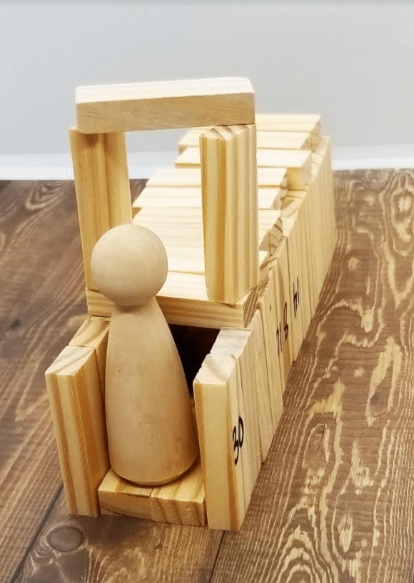 stem shows a wooden structure and a little wooden figure sitting on it.