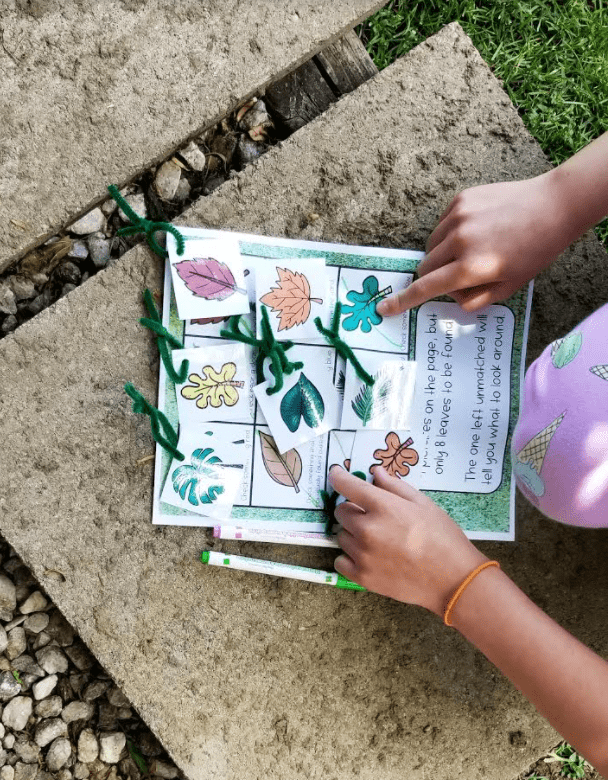 treasure hunt shows a child pointing at leaves in a picture.