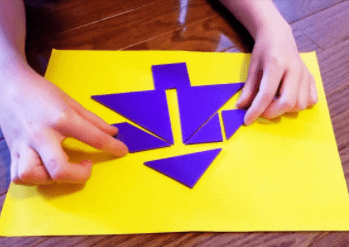 puzzles for kids shows a child making a tree from tangram pieces.