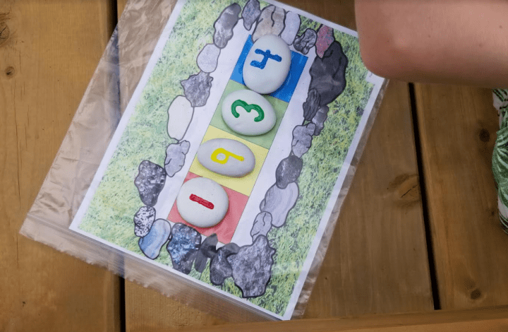 summer games for kids shows a printed clue with rocks with numbers placed on them.
