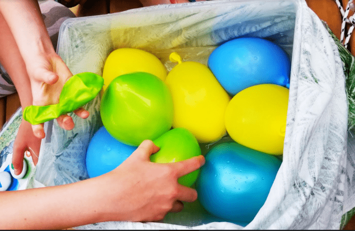 outdoor escape rooms shows children grabbing water balloons.