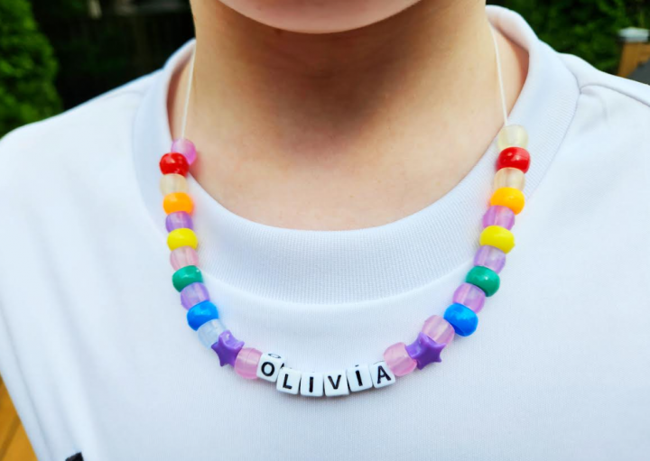 creative back to school activity shows a child wearing a colorful bead necklace with the name Olivia.