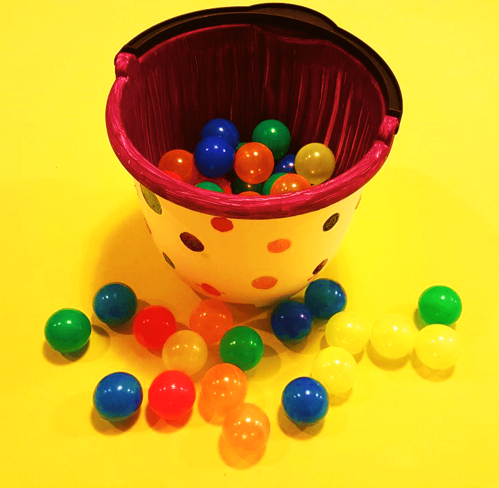 back to school shows a bucket with plastic balls around and in it.