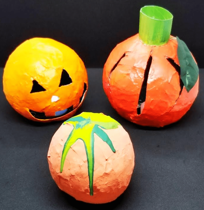 Halloween craft  for kids shows three paper mache pumpkins.