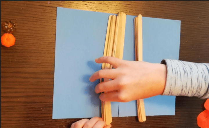 halloween stem for kids shows a child building a bridge with sticks.