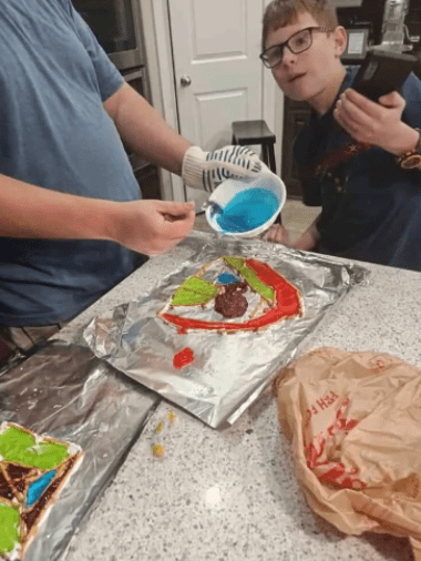art project for kids an adult and child are pouring a liquid into a tin foil tray