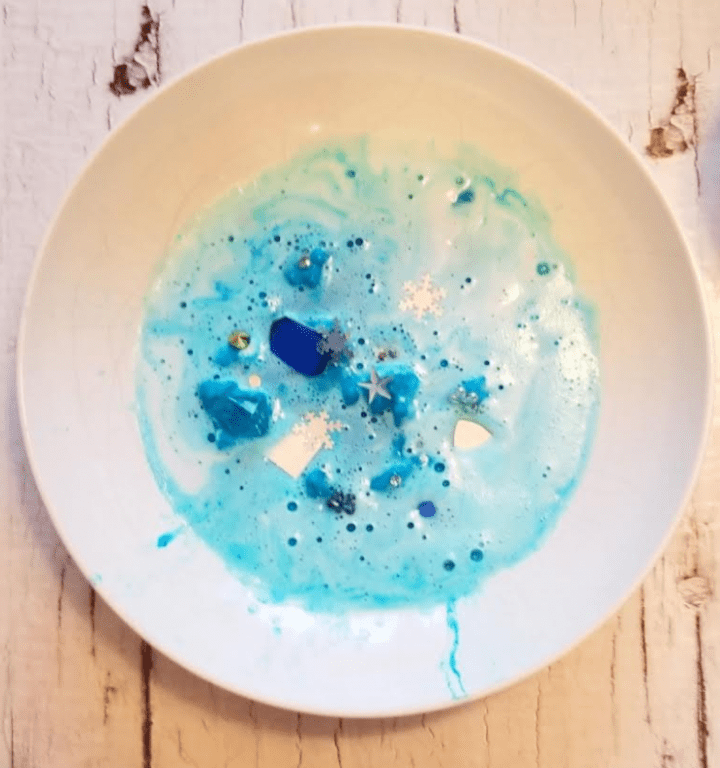stem activity image shows a white bowl with fizzing blue bubbles with gems and trinkets in it.