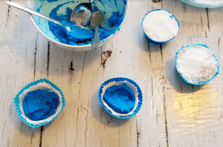stem activities for kids and the image shows cupcake liners with white and blue stuff in them.