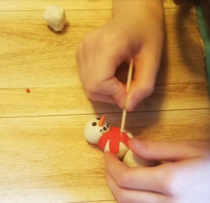 STEAM activity and a photo of a child adding details to a clay snowman