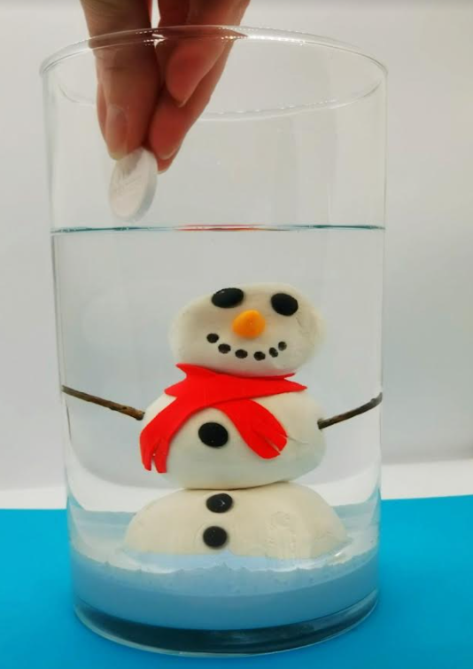 science experiments for kids showing a clay snowman in a jar filled with baby oil and a person dropping a tablet into the oil