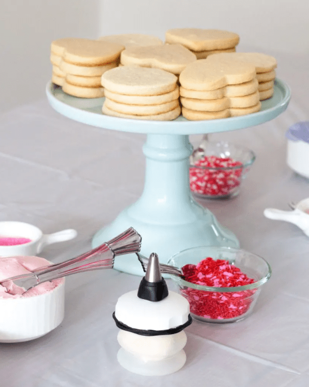 cookies on a white stand and decorating candies and icing