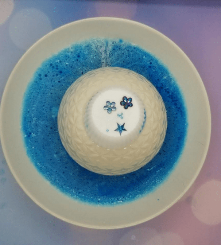 STEAM for kids shows a large bowl with blue liquid and a white puck on top with decorations on top.