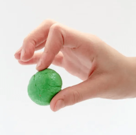 St patricks day STEM activities for kids shows a child holding a green bouncy ball