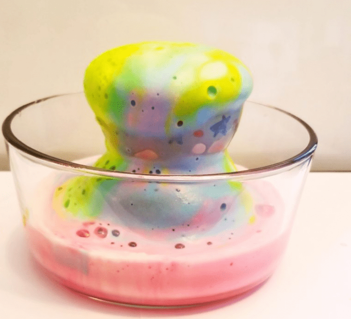 St patricks day STEM activities for kids shows a foaming rainbow in a bowl.