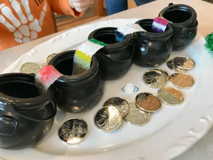 stem activity shows five black small cauldrons with paper towel hanging over the side of each into the next one with rainbow colors on it