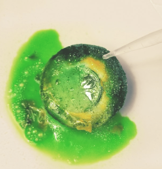 STEM activities for kids shows a fizzing green baking soda puck with a coin showing through