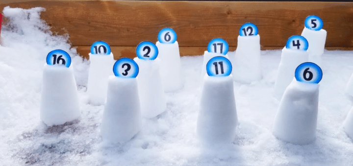outdoor learning activity in the snow shows snow towers with numbers sticking into the top