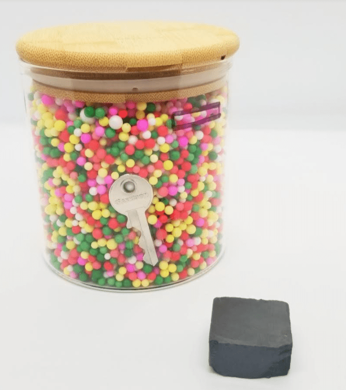 escape room ideas include a clear jar with colorful foam balls and a key