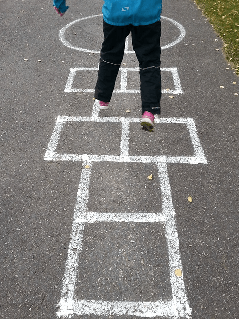 active games shows a child jumping on a hop scotch space.
