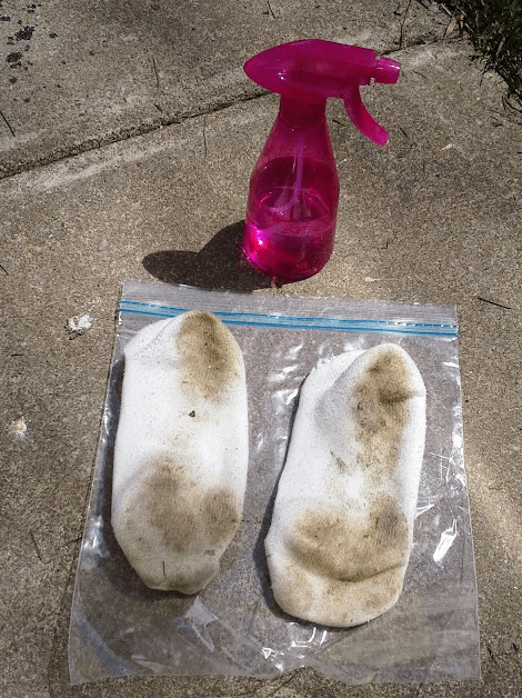 science experiment for kids shows two socks that look dirty and a pink spray bottle