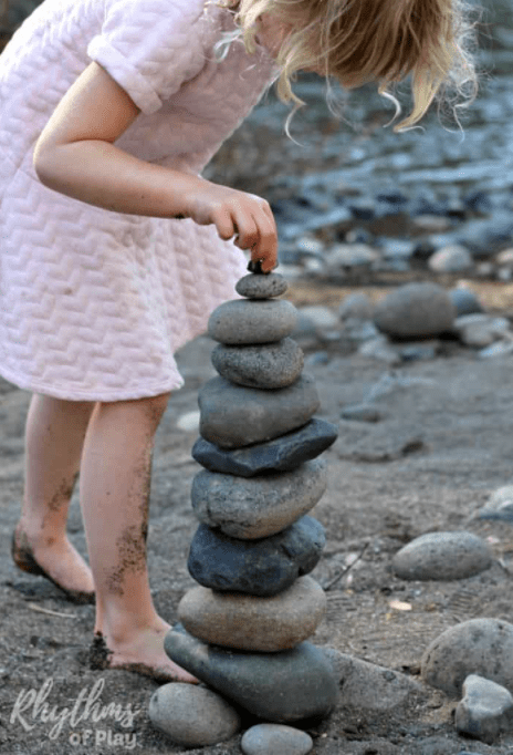 outdoor learning activities image shows a child building with rocks