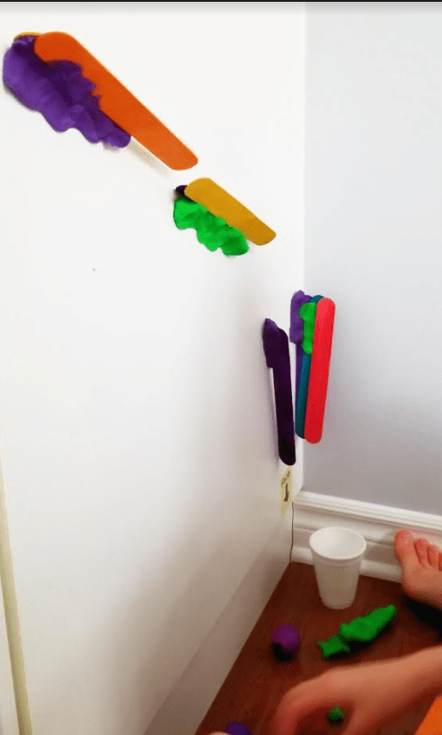 STEM challenge shows a ramp on the wall made from tongue depressors and play dough