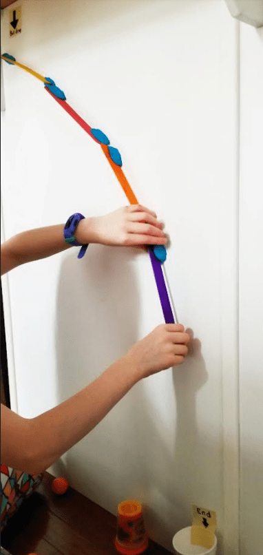 STEM shows a child sticking colorful tongue depressors to a wall with play dough
