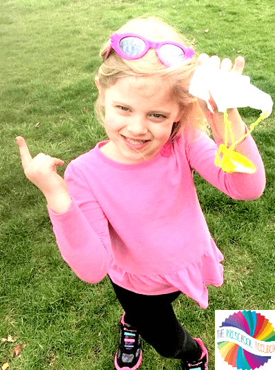 spring stem activities shows a child outside with a homemade parachute
