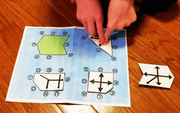 escape room activities shows a child putting a triangle shape on a piece of paper
