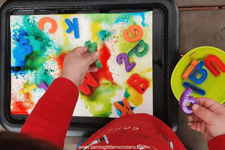 phonological awareness shows a child playing with letters and paint.